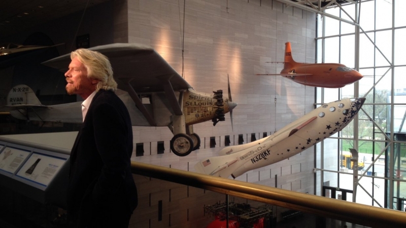  Ричард Брэнсон позирует на фоне аппаратов Spirit of St. Louis, SpaceShipOne и X-1 в галерее &laquo;Вехи полёта&raquo; 